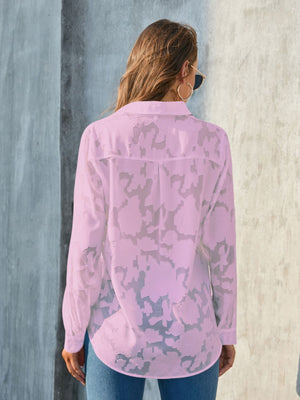 Pink sheer button-down blouse with all-over floral embroidery and long sleeves.