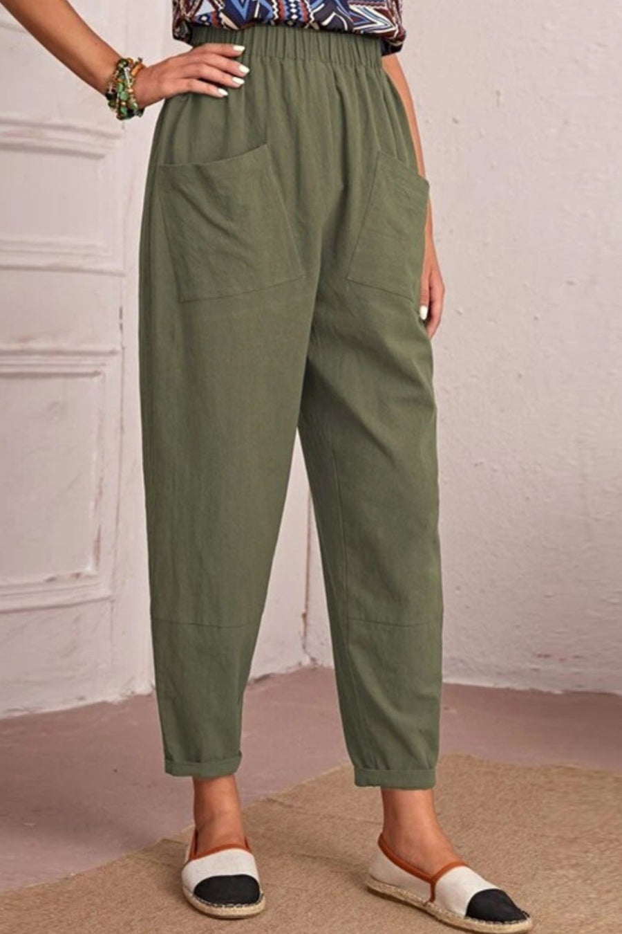 Matcha green linen tapered trousers with elastic waist and large front pockets.
