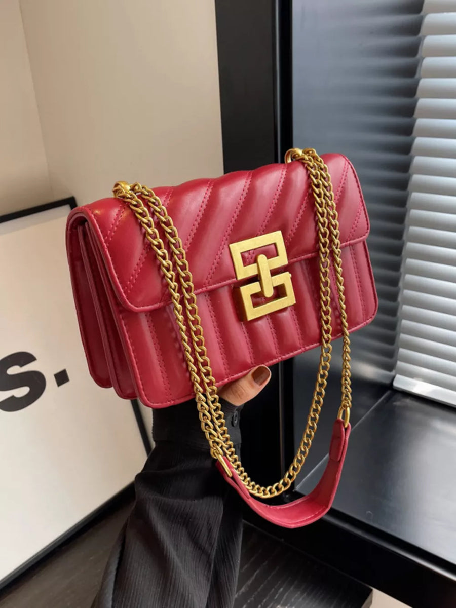Chic quilted crossbody bag in wine red with gold chain and clasp detail.