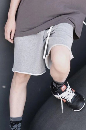 Gray jogger shorts with raw edge hem and white drawstring
