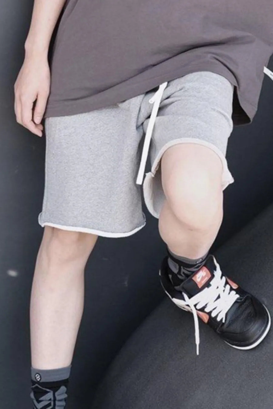 Gray jogger shorts with raw edge hem and white drawstring