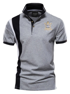 Gray polo shirt with colorblock detail, crest embroidery, and black collar trim.