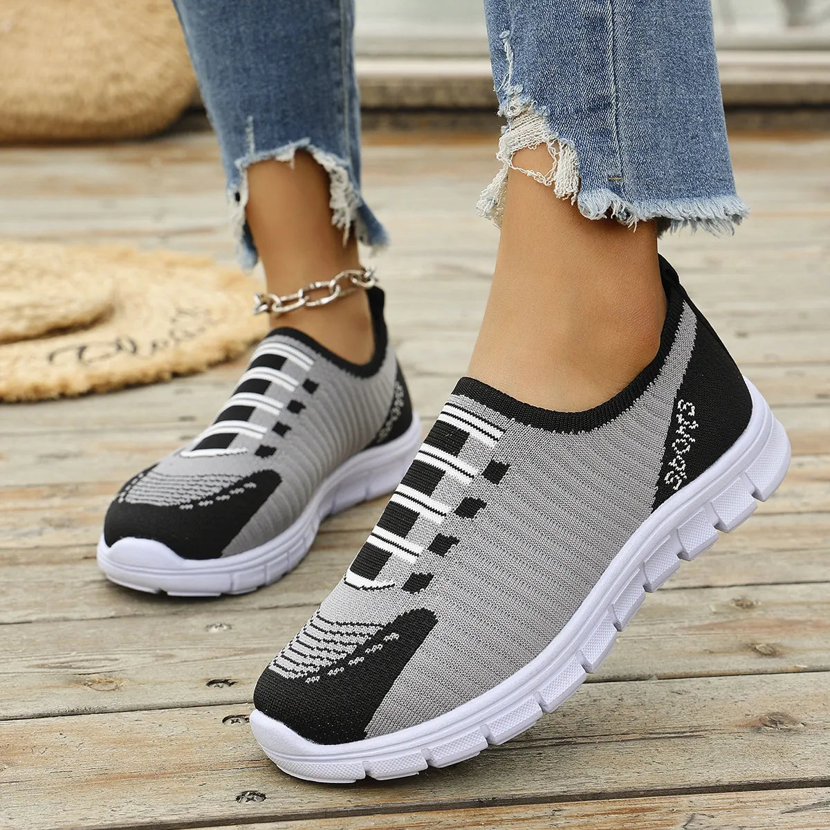 Grey ribbed knit slip-on sport sneakers with black accents and white soles.