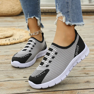 Grey ribbed knit slip-on sport sneakers with black accents and white soles.