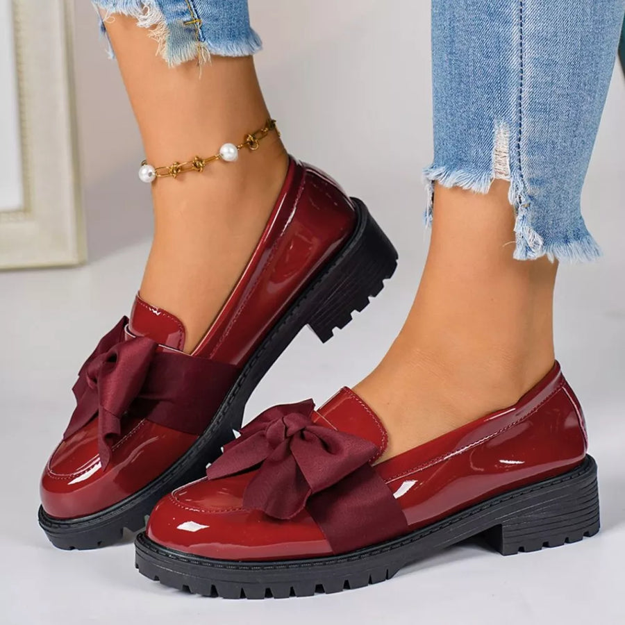 Burgundy patent loafers with bow detail and lug sole.