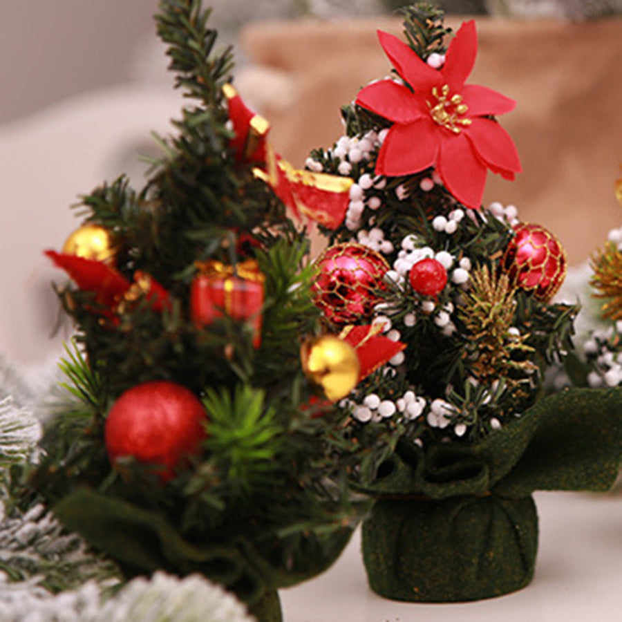 Miniature festive forest centerpieces with red ornaments, gold baubles, and red bows.