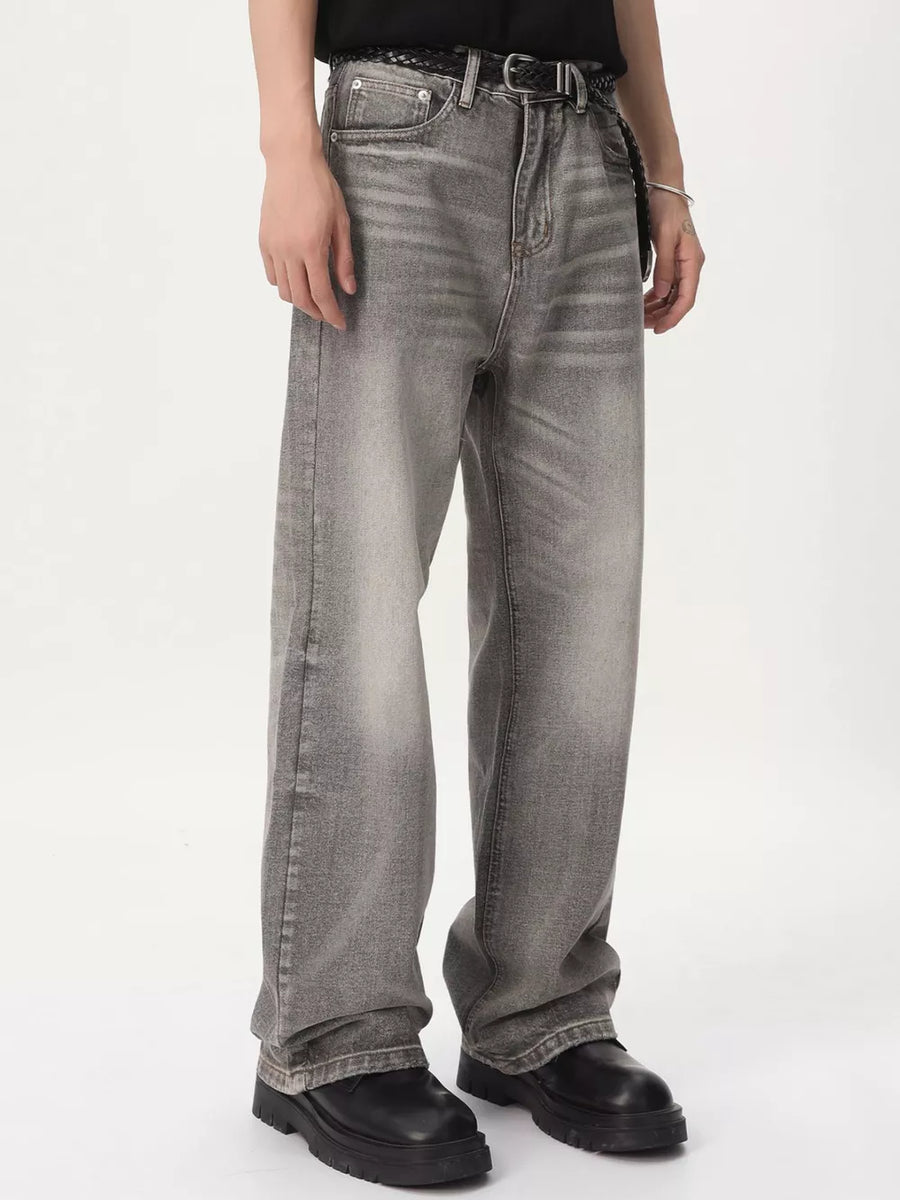 Men's vintage wash wide leg jeans in gray cotton, styled with a black belt.