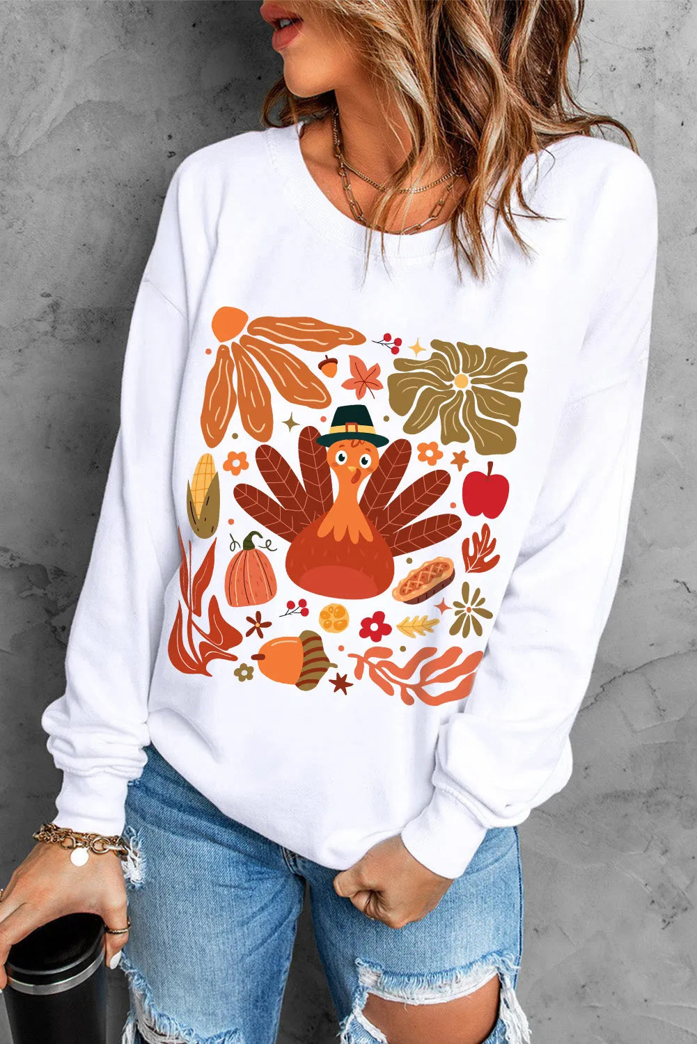 White round neck sweater with a playful Thanksgiving turkey and fall harvest graphic print.