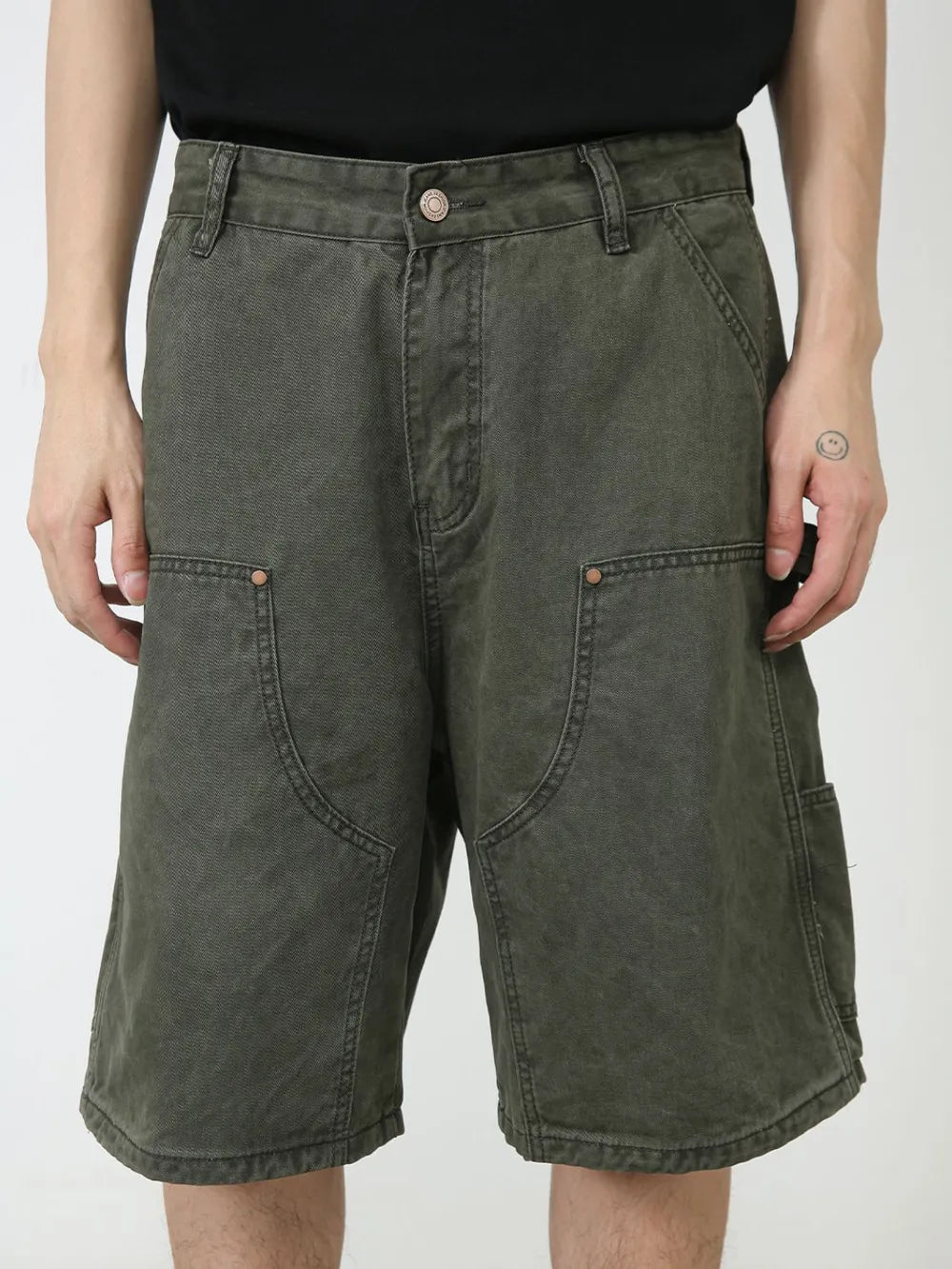 Washed olive denim carpenter shorts with utility pockets and button fly.