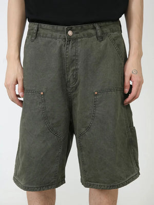 Washed olive denim carpenter shorts with utility pockets and button fly.