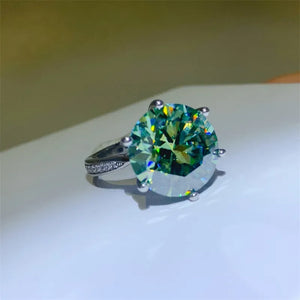 Prismatic cut solitaire ring in silver with a large green gemstone and small accent stones on the band.