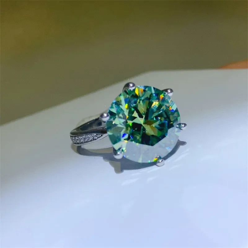 Prismatic cut solitaire ring in silver with a large green gemstone and small accent stones on the band.