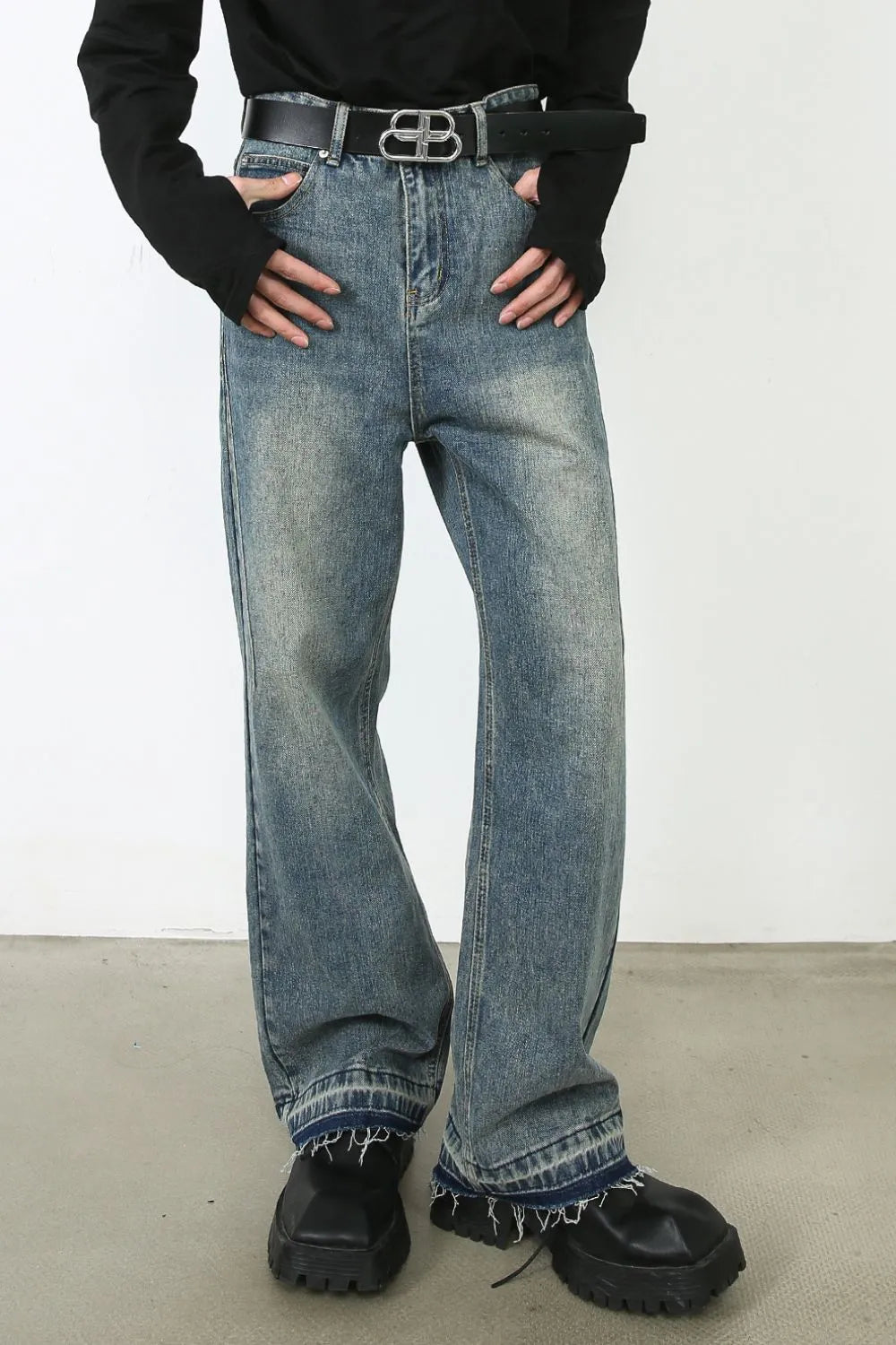 Distressed wide-leg jeans in medium wash denim with a raw hem and faded details.