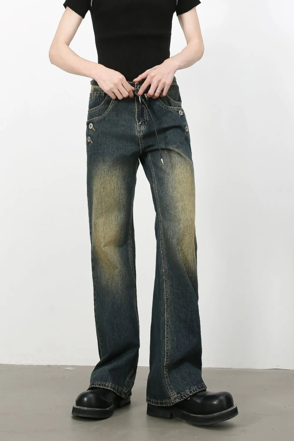 Dark wash bootcut jeans with faded details and button accents