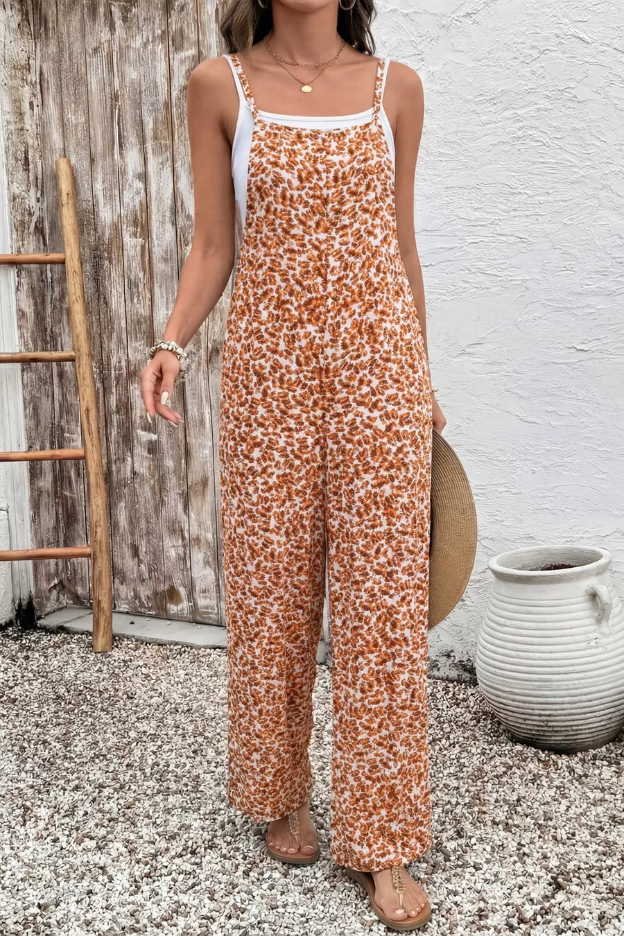 Abstract floral wide-leg romper with pockets, featuring spaghetti straps and a white tank top.