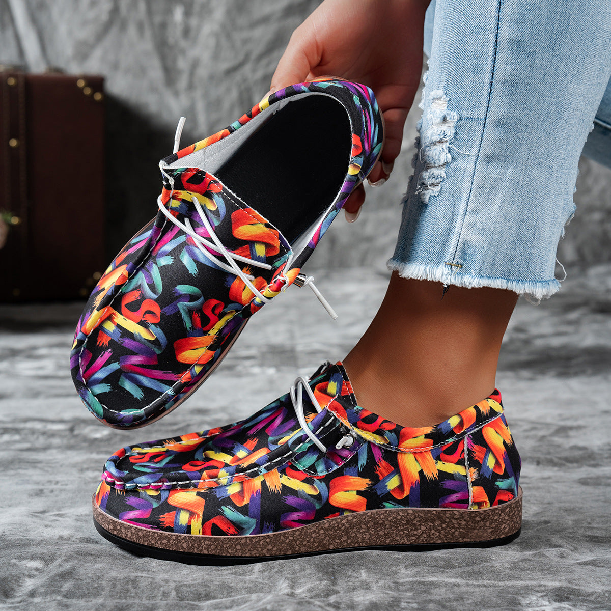Printed casual slip-on loafers with abstract brushstroke pattern in black and multicolor.