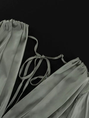 Sage green satin dress with tie-back detail and ruched neckline