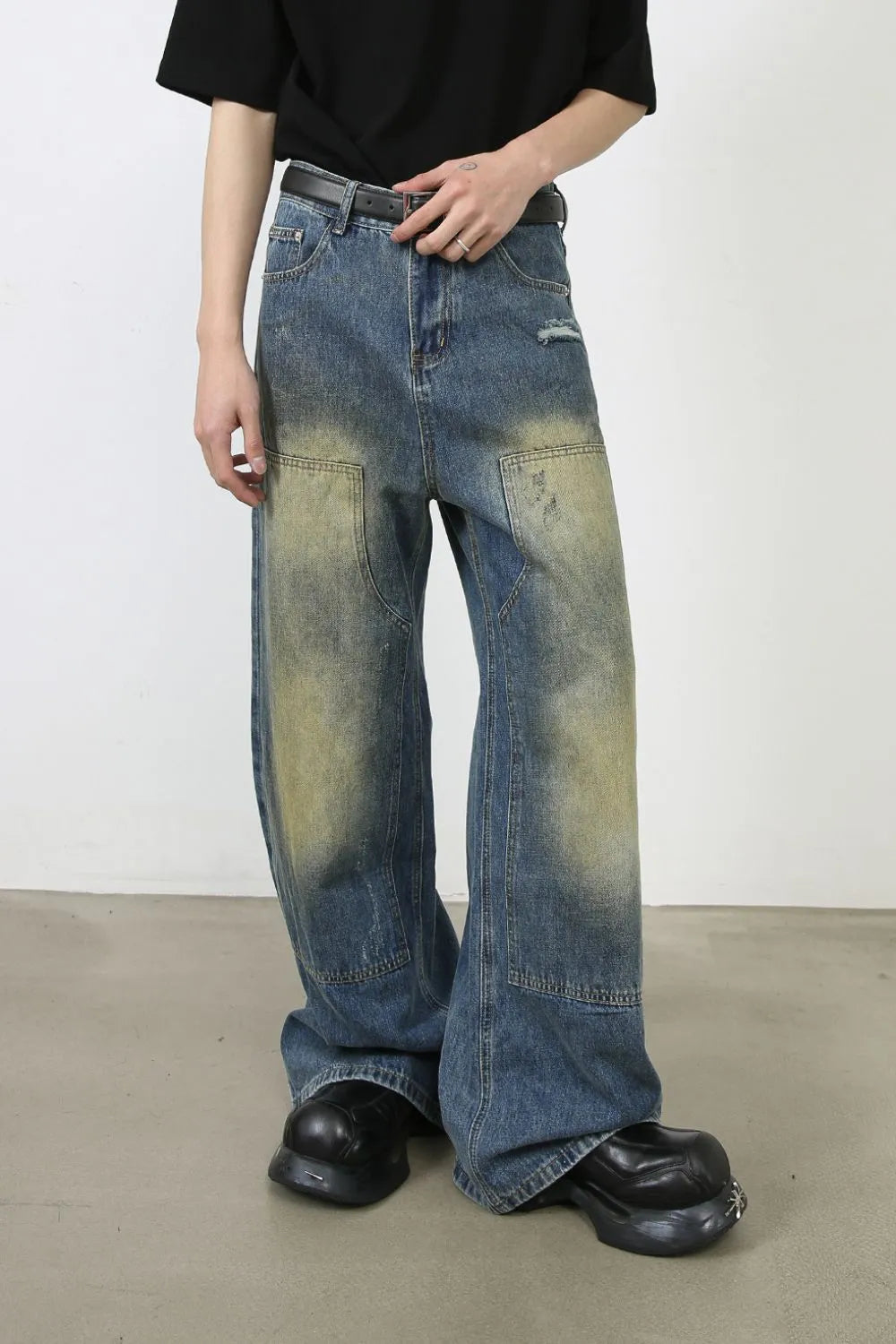 Faded patchwork denim palazzo trousers in medium wash with distressed details and wide leg.