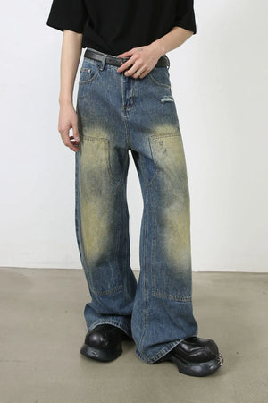Faded patchwork denim palazzo trousers in medium wash with distressed details and wide leg.