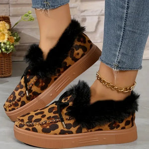 Leopard print suede loafers with black shearling trim and brown soles.