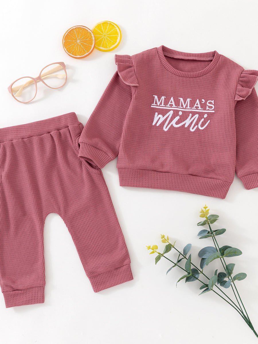 Toddler dusty rose waffle knit top with ruffled sleeves and "Mama's Mini" graphic, paired with matching pants.
