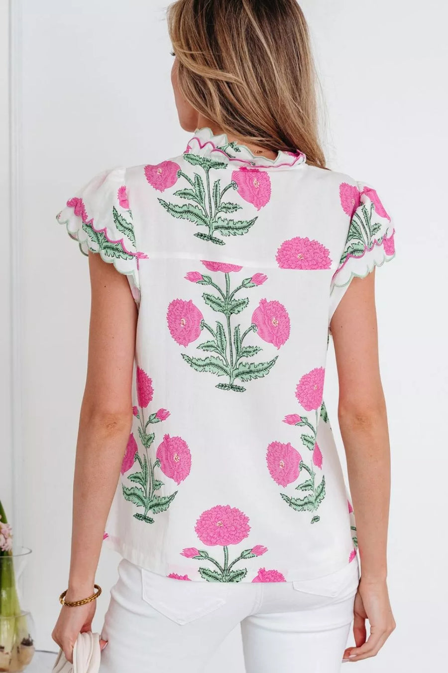 White cotton blouse with vibrant pink floral print, short sleeves, and scalloped trim.