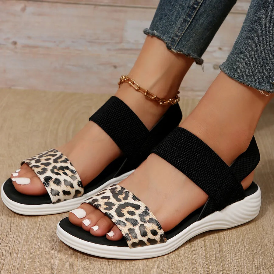 Leopard print elastic strap sandals with black elastic bands and white soles.
