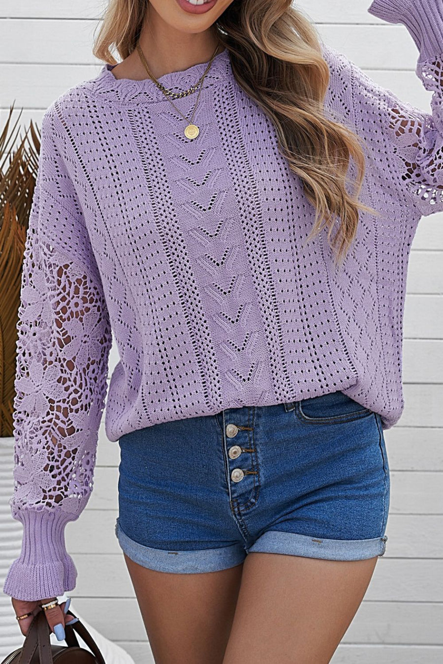 Lavender openwork knit sweater with lace sleeves and detailed stitching.