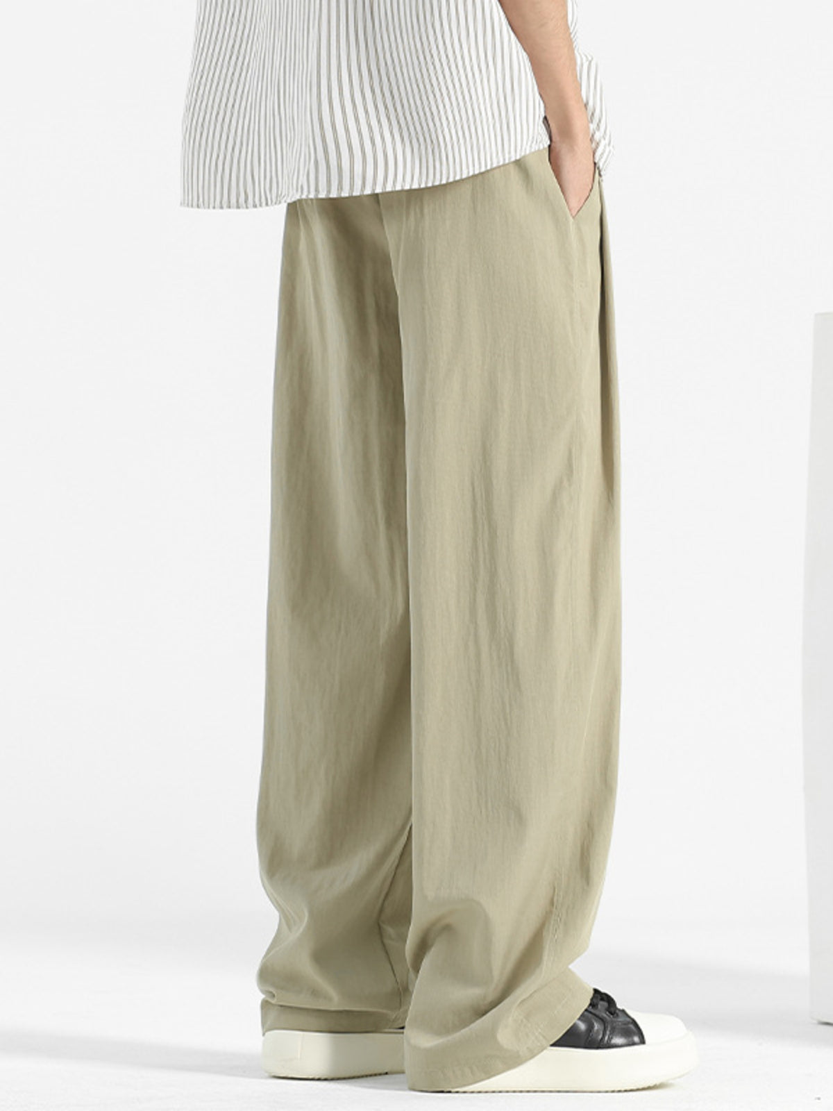 Plus-size sage sweatpants with loose fit and elastic waistband, shown from the side.