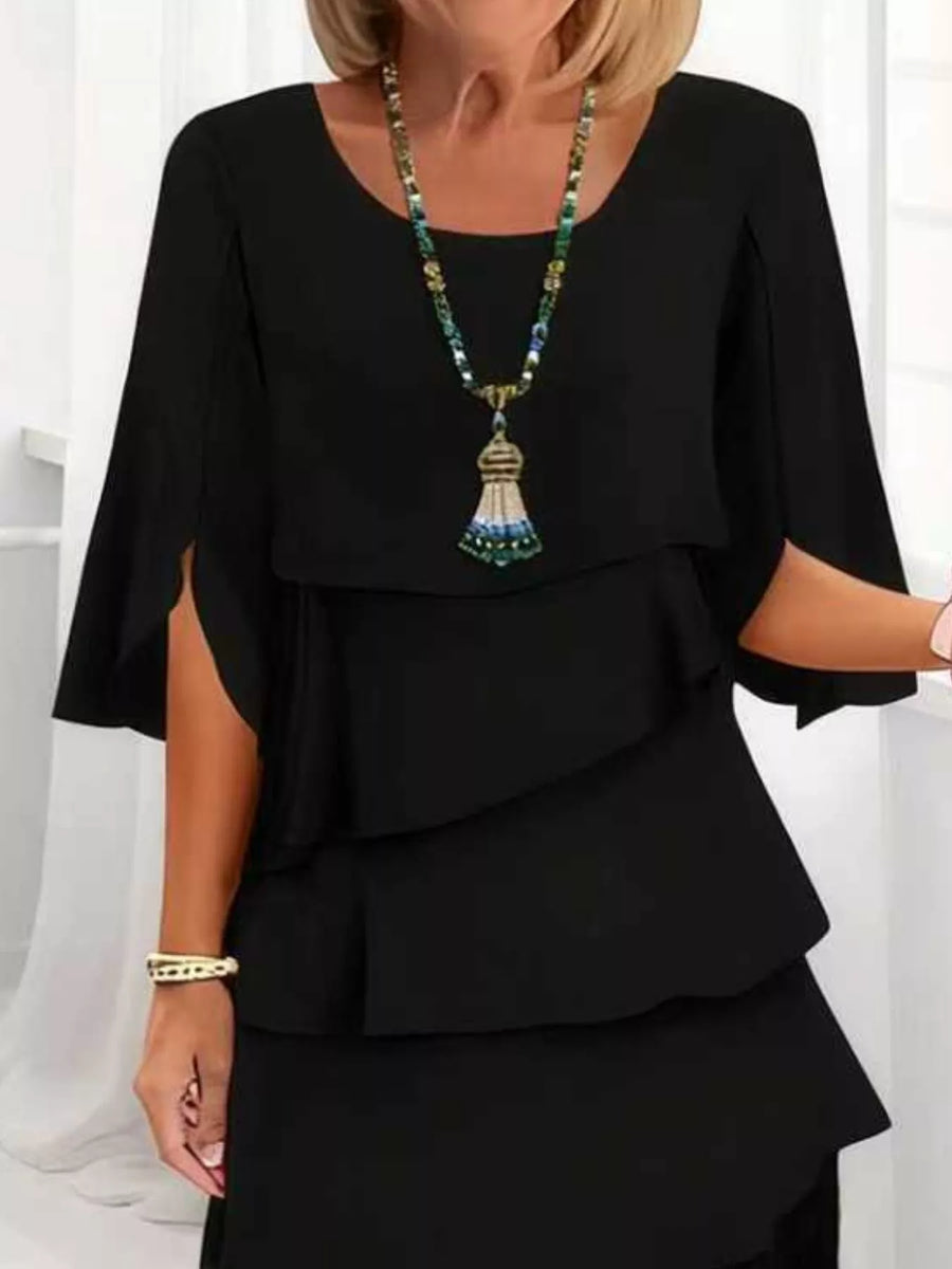 Black ruffled tiered dress with flutter sleeves and a scoop neckline.