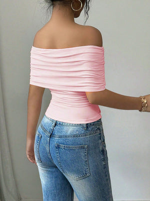 Pink asymmetrical ruched off-shoulder top with a bandeau neckline.