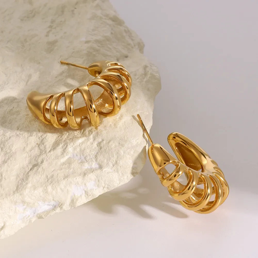Gold sculptural ribbed hoop earrings with 18K gold plating.
