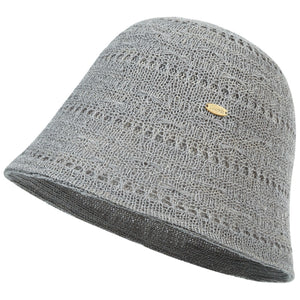 Gray knitted bucket hat with open weave pattern and gold logo detail.