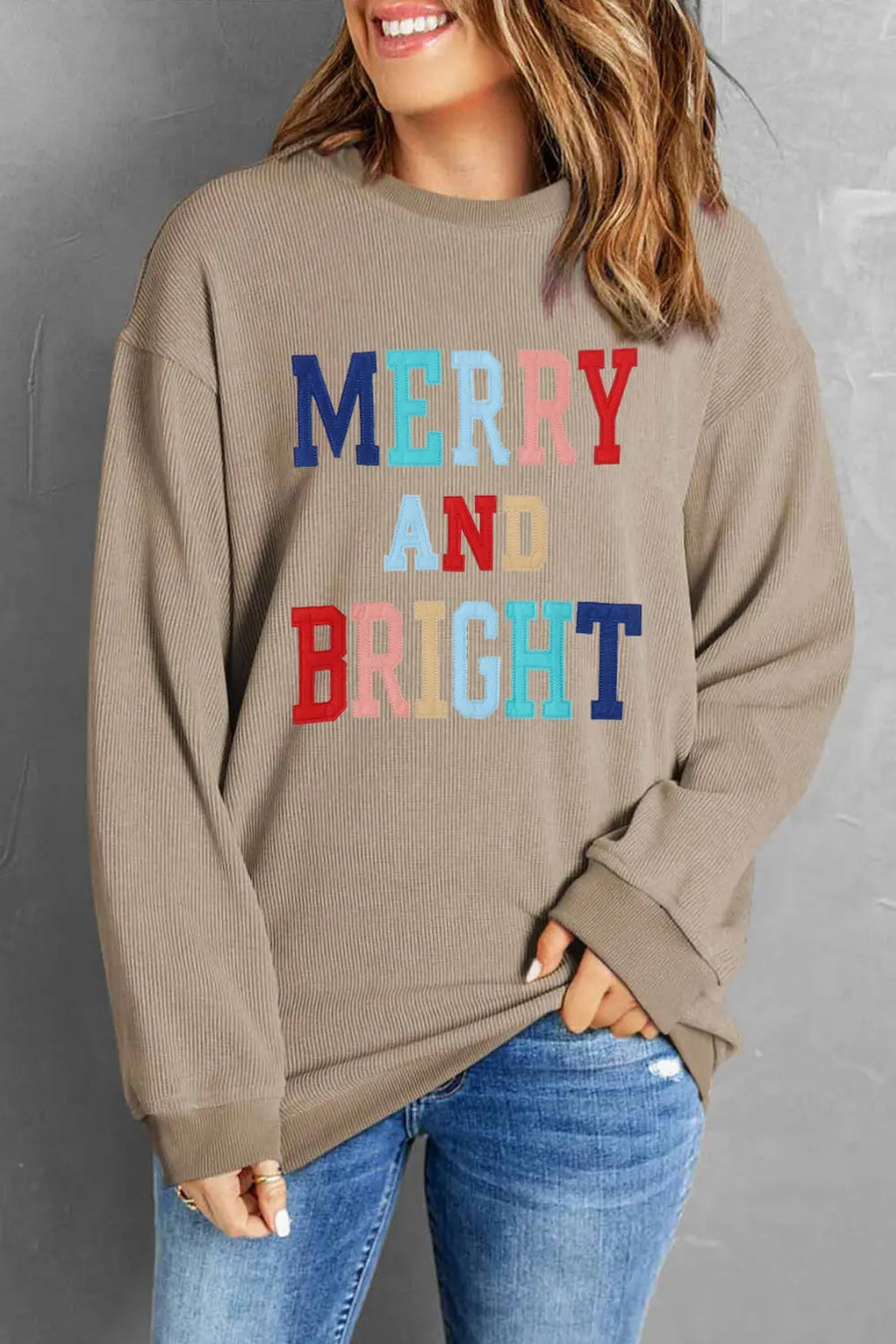 Camel ribbed sweatshirt with "Merry and Bright" text in colorful letters