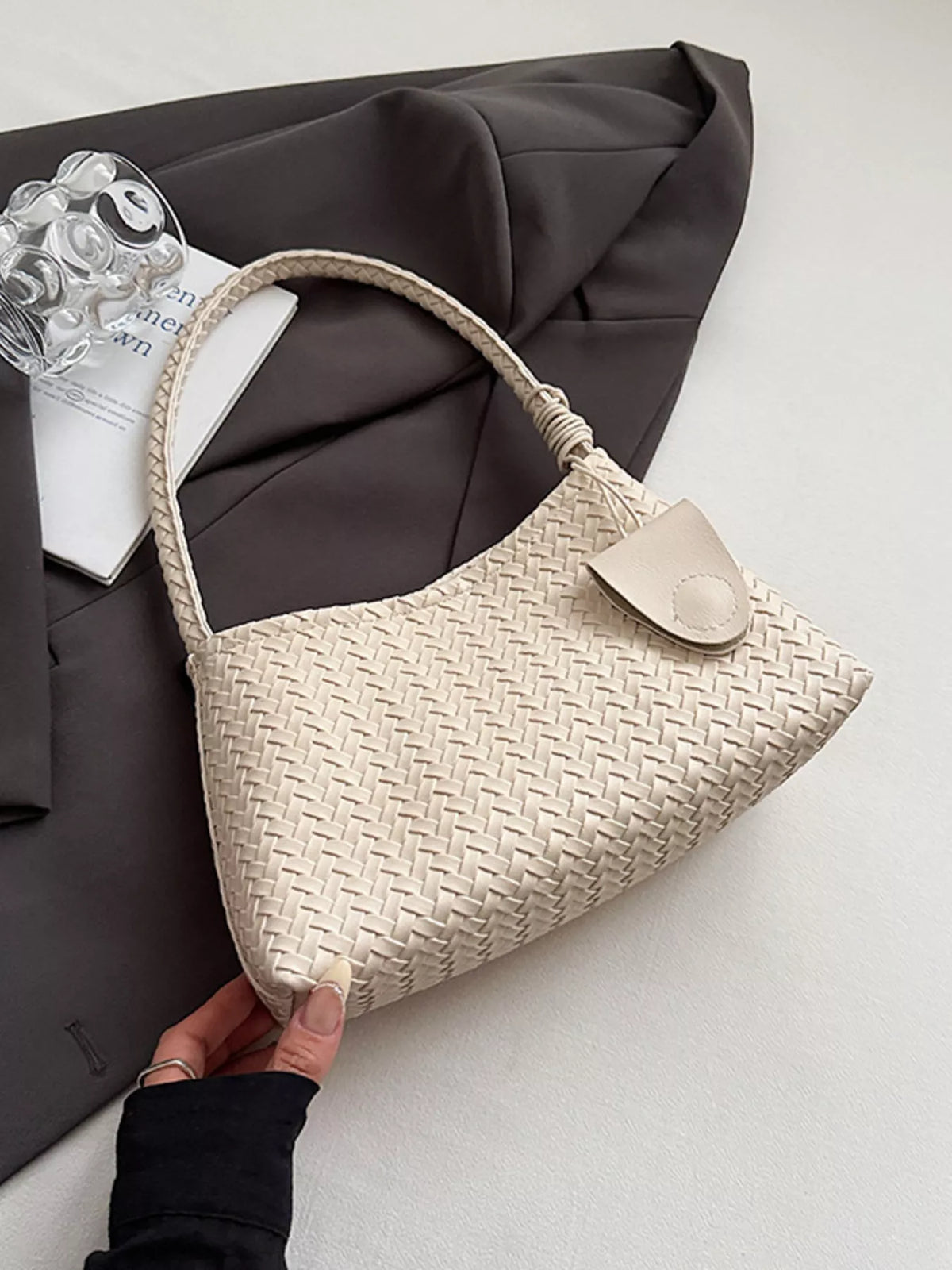Off-white woven shoulder bag with braided strap and leather tab detail