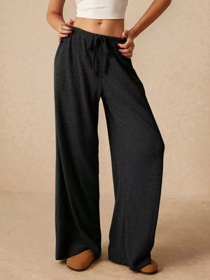 Black ribbed wide-leg drawstring pants with a relaxed fit.