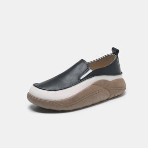 Black and white slip-on sneakers with a sculpted platform sole.