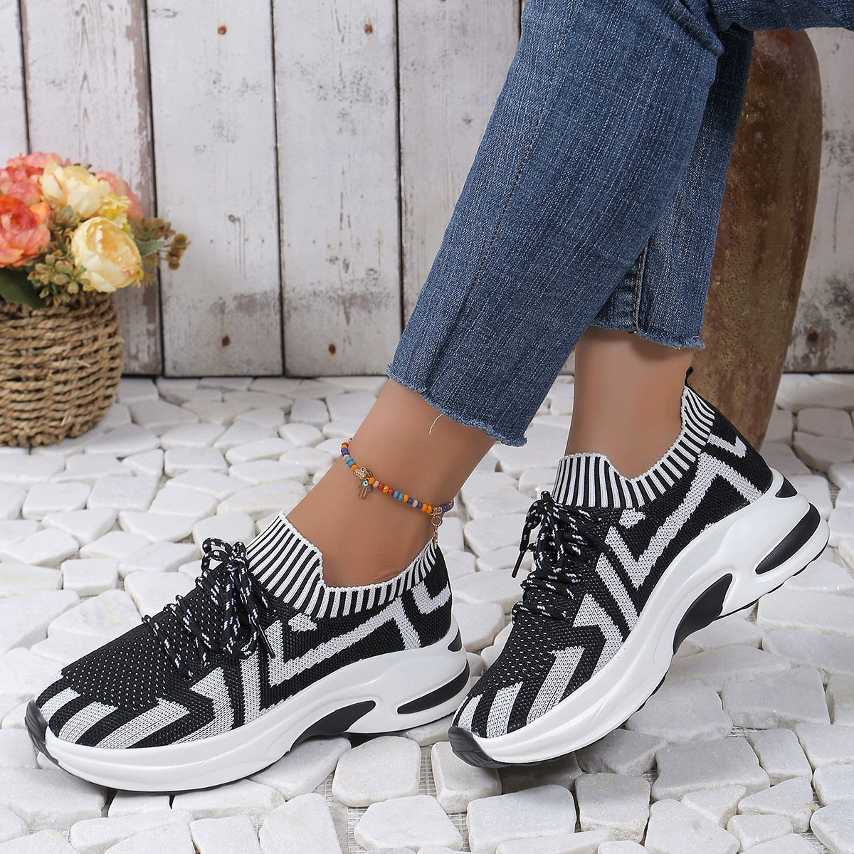 Geometric knit platform sneakers with black and white zigzag pattern and white soles.
