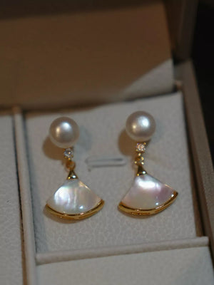 Elegant fan-shaped pearl earrings with gold trim and diamond accents.