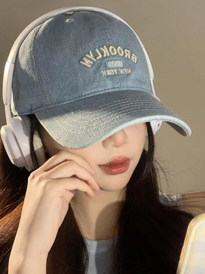Light blue baseball cap with embroidered Brooklyn text and a white headband.