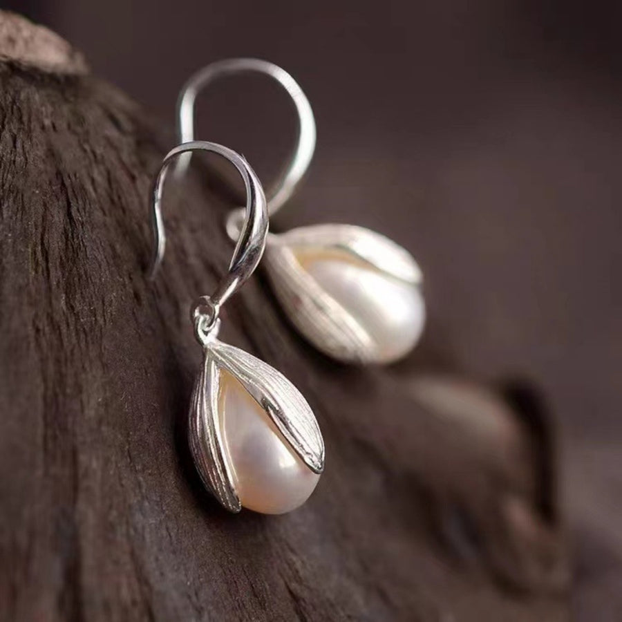 Lustrous pearl drop earrings in silver with a delicate petal design.
