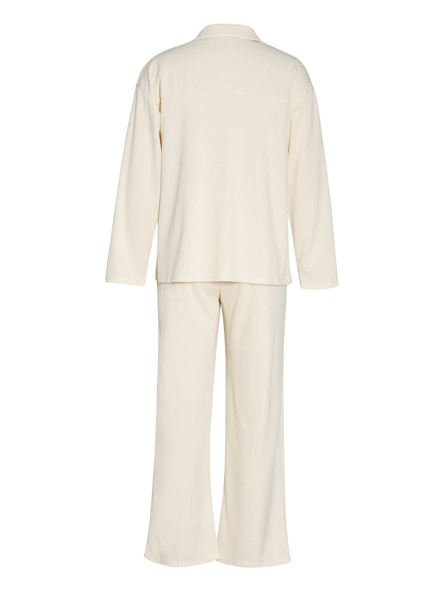 Cream ribbed knit lounge set with relaxed fit long sleeve top and wide leg pants.