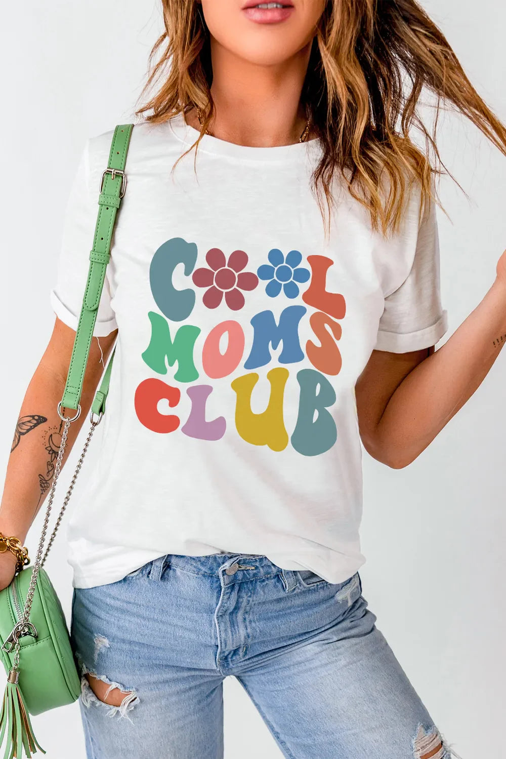 White graphic tee with colorful "Cool Moms Club" text and flower details