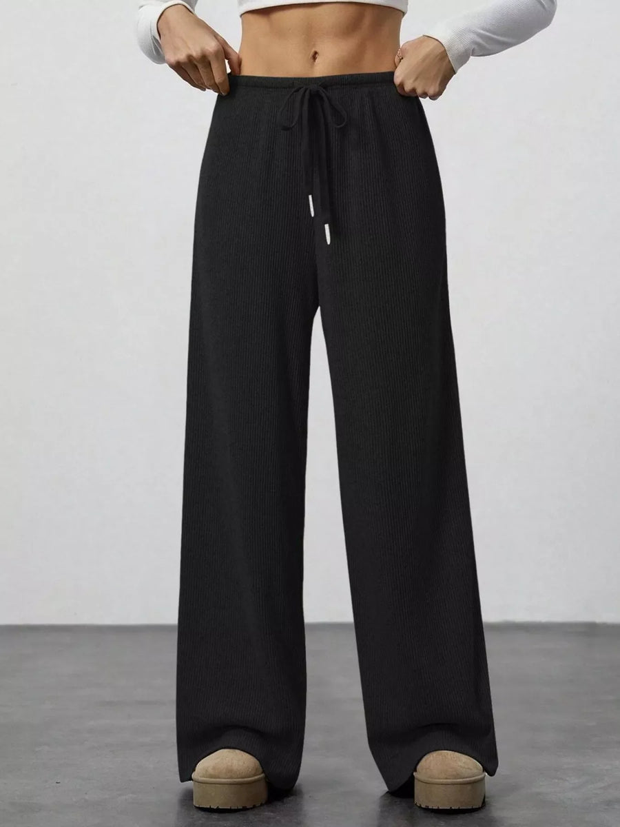 Black ribbed wide-leg pants with drawstring waist and white tips.