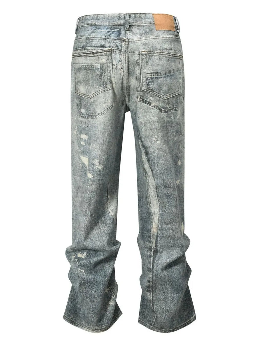 Distressed wide-leg jeans in medium wash denim with painterly details and a relaxed fit.