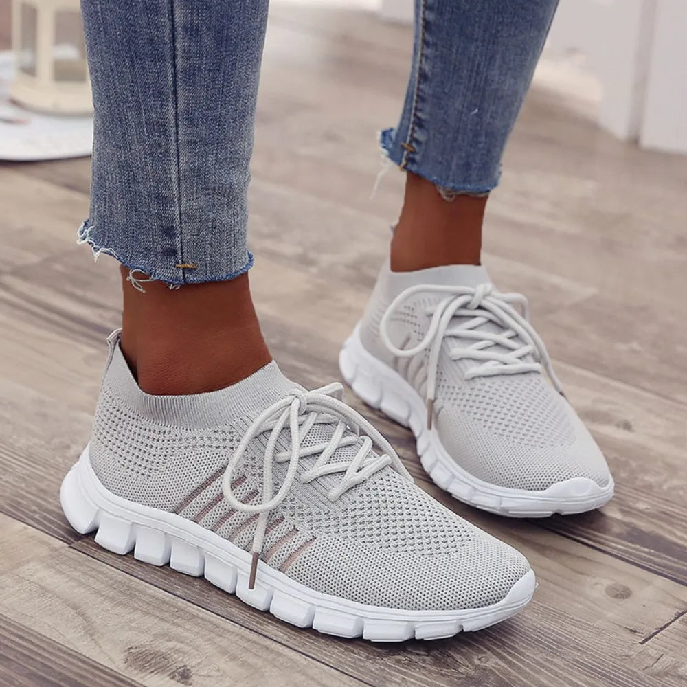 Gray knit runner sneakers with ribbed detail and white laces.