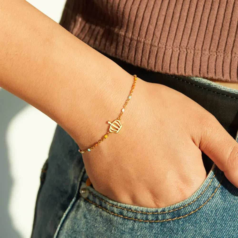 Gold crown charm bracelet with colorful enamel beads on a sterling silver chain.