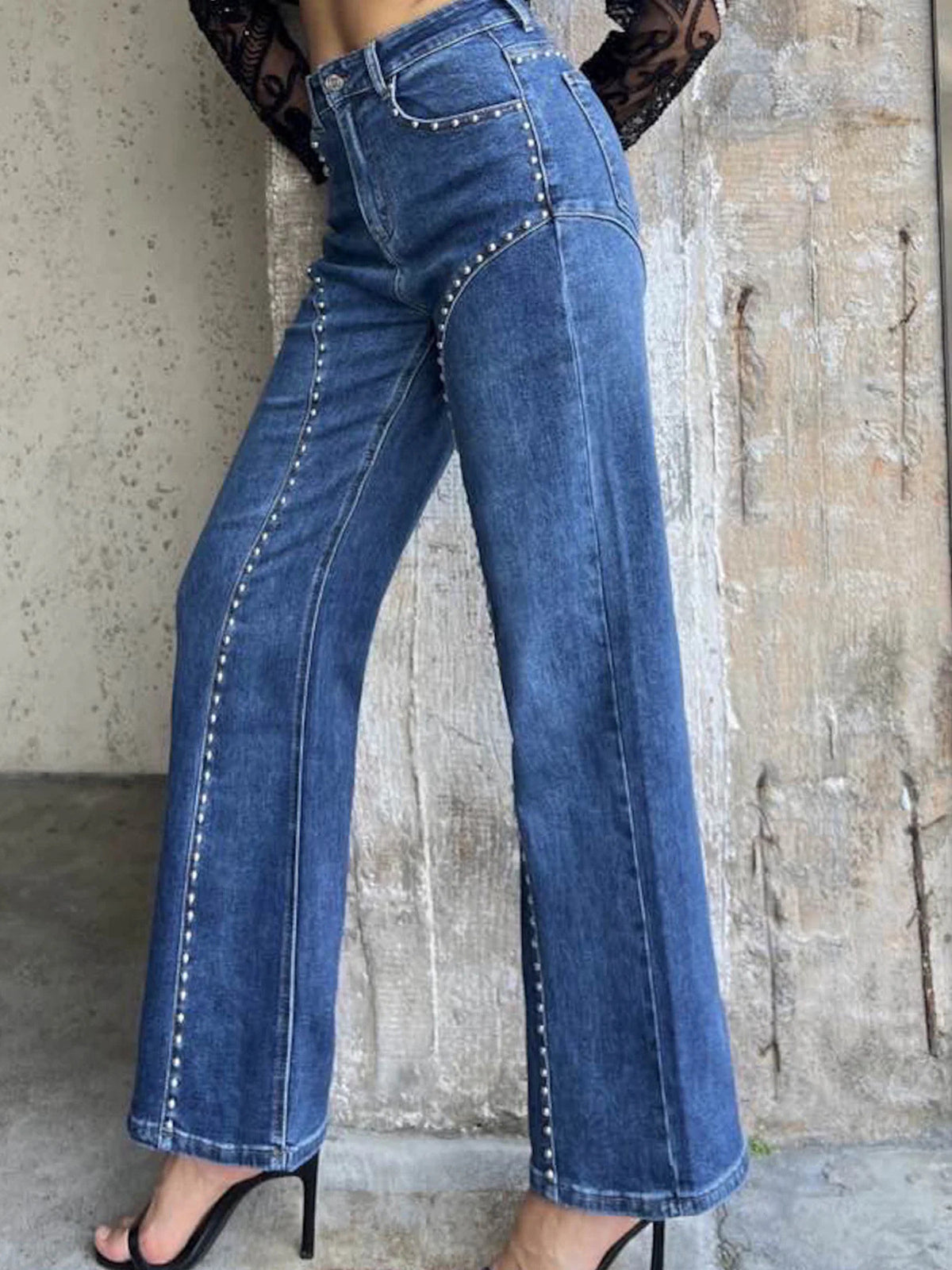 Studded high-waisted wide-leg jeans in blue denim with silver stud detailing.