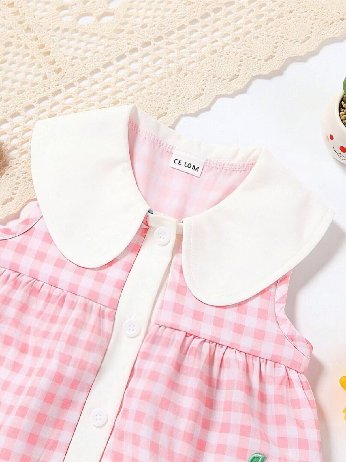 Pink gingham toddler dress with white Peter Pan collar and button front.