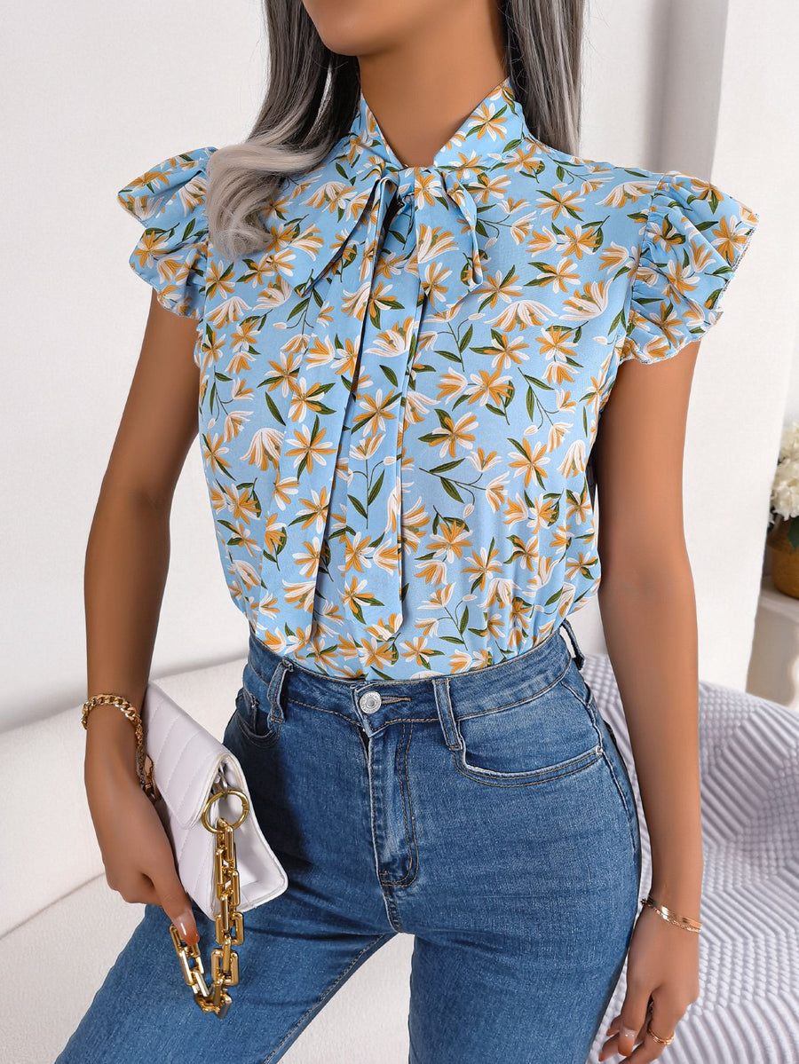 Light blue floral blouse with tie neck and ruffle sleeves.